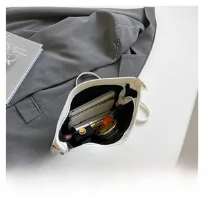 Vue intérieure d'un sac seau en cuir blanc montrant sa grande capacité pour les objets