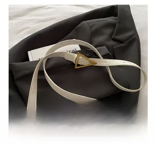 Detailansicht der weißen Kunstledertasche mit Schlangenmuster und goldener Dreieckschnalle