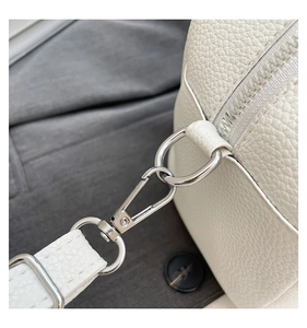 Close-up of white lychee pattern leather bag showing silver zipper and metal lobster clasp