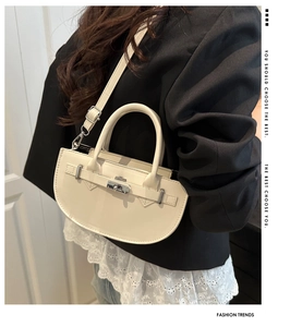 Détail d'un sac demi-lune blanc crème avec fermoir rotatif argenté et finition mate lisse