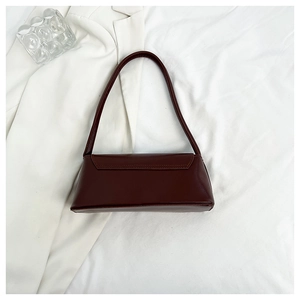Macro shot of dark brown matte leather baguette bag with retro shoulder strap