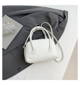 Detail of white litchi pattern leather mini Boston bag with dual handles and strap