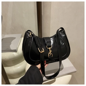 Détail du sac demi-lune en cuir verni noir avec boucle en métal doré et fermeture éclair
