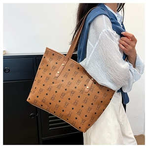 Detail of a brown tote bag featuring bear patterns and sleek shoulder straps for work