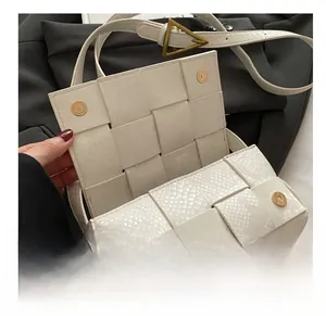 Details einer weißen Umhängetasche mit Schlangenmuster, Magnetknöpfen und Goldschnalle
