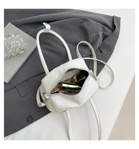 Macro shot of the white crossbody bag interior showing storage space and zipper