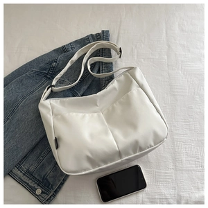 Detailed top view of a white quilted puffer bag with adjustable strap and zipper closure