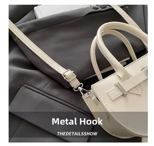 Détail de la boucle en métal argenté et de la bandoulière de ce sac en cuir blanc chic