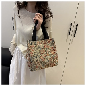 Detail of floral canvas tote bag showing the thick fabric texture and black handles