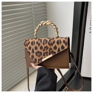 Detail of leopard print flap and gold braided metal handle on brown shoulder bag