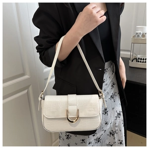 Detail of white crocodile embossed shoulder bag with elegant gold U-shaped metal buckle