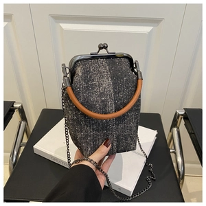 Détail du sac seau en tweed avec poignée en cuir et fermoir en métal rétro
