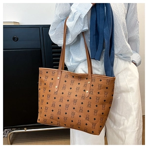 Detail of bear print pattern and metal studs on brown faux leather tote bag