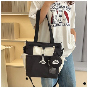 Détail du cabas en toile avec liseré contrasté, badge nuage et petite pochette ronde amovible