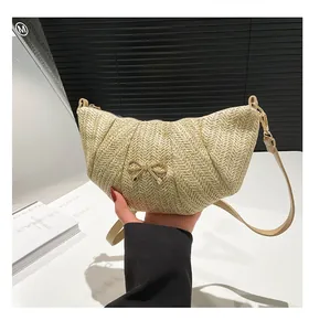 Detail of beige woven half-moon shoulder bag with golden bow buckle and fine strap