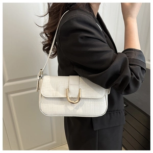 Detail of white crocodile embossed PU leather shoulder bag with golden U-shaped buckle
