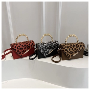 Detailed display of leopard print flap bags with gold braided handles in three colors
