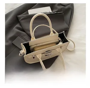 Vue de dessus de l'intérieur du sac à main en cuir crème montrant le rangement du mobile