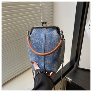 Détail du sac bandoulière en denim bleu avec paillettes et poignée marron