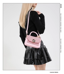 Dettaglio borsa rosa glitterata con fibbia a D dorata e tracolla sottile elegante