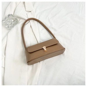 Detailed view of brown faux leather shoulder bag with elegant gold flip-lock buckle