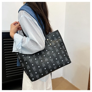 Detail of the large black tote bag with light blue cartoon bear print and leather straps