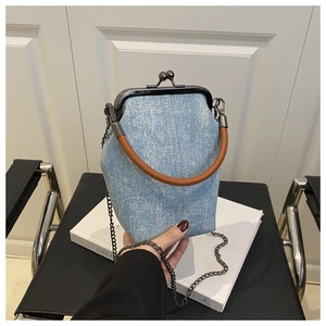 Détail du sac en jean bleu avec strass, fermoir vintage et poignée marron ronde