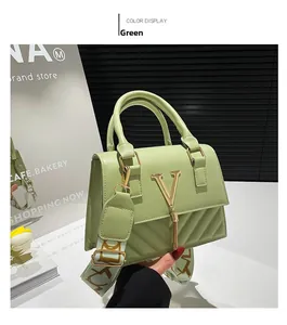 Detail of avocado green crossbody bag with V-shaped metal logo and long tassel charm