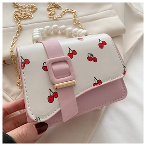 Detail of pink and white crossbody bag with cherry prints and pearl handle