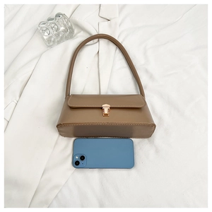 Detail of a brown PU leather baguette bag with a gold rectangular metal buckle closure