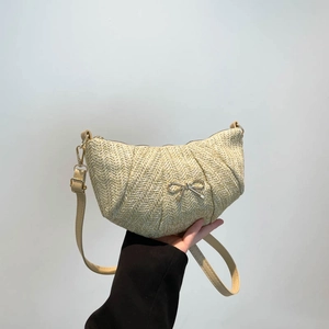Woven crescent shoulder bag with silver bow accent and adjustable strap for summer fashion