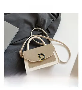 Dettaglio della patta intrecciata e della fibbia a D dorata sulla borsa a tracolla beige