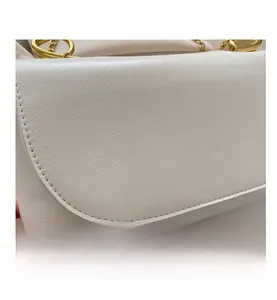 Dettaglio della borsa in pelle PU bianca con trama martellata e anello in metallo dorato