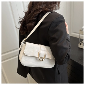Chic off-white crocodile embossed underarm bag with gold horseshoe buckle on model