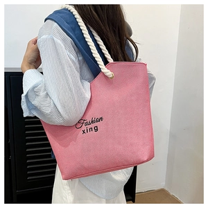 Close-up of pink striped canvas tote bag with fashion lettering and thick rope handles