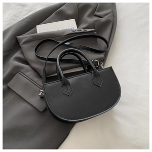 Détail du sac demi-lune noir en cuir PU sur blazer gris avec bandoulière ajustable