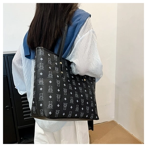 Close-up of black tote bag with cute bear prints and metallic gold rivet details