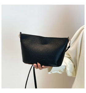 Détail du sac seau en cuir grainé noir avec crochets dorés et logo embossé chic