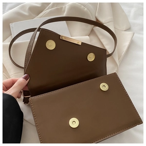 Close-up of dark brown leopard print shoulder bag showing magnetic gold buckle details