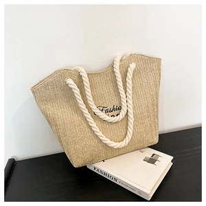 Close-up of handmade straw tote bag with Fashion embroidery and white cotton rope handles