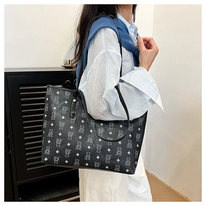 Detail of black tote bag with white bear pattern print and long leather shoulder straps
