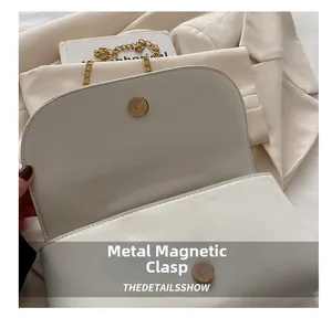 Dettaglio della borsa in pelle bianca con fibbia magnetica dorata e patta testurizzata