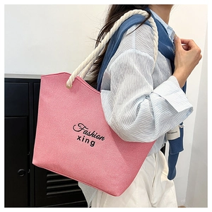 Pink canvas tote bag detail featuring rope handles and black Fashion lettering