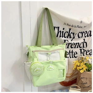Detail of light green and white canvas tote bag with shoulder strap and small round pouch