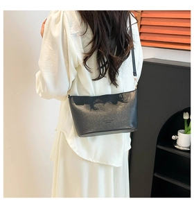 Gros plan sur le sac seau en cuir noir montrant la texture et la boucle en métal doré