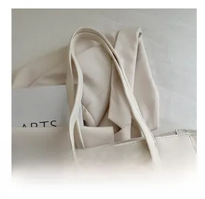 Close-up of comfortable shoulder straps on minimalist cream white fashion tote bag