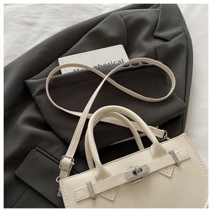 Gros plan du sac à main en cuir beige avec fermoir argenté et texture grainée fine