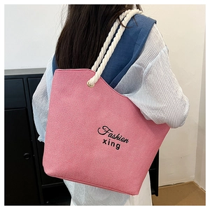 Pink canvas shoulder bag with rope handles and Fashion xing logo shown on model