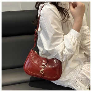 Détail du sac bandoulière en cuir verni bordeaux avec fermoir mousqueton doré vintage