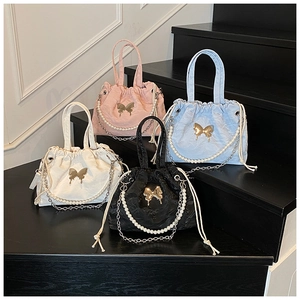 Detail view of stylish drawstring handbags in four colors with pearl chains and butterfly clips